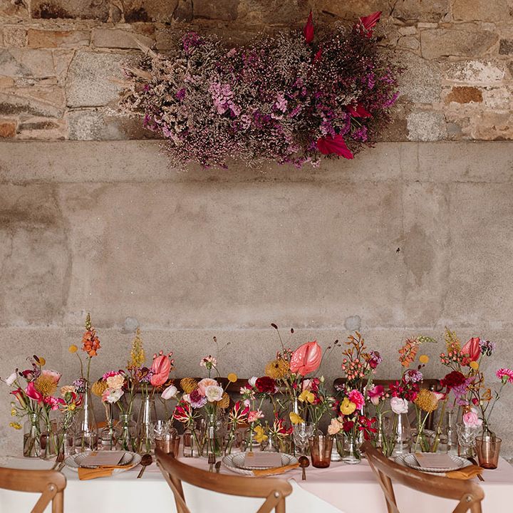 Spring wedding table decor with a gypsophila flower cloud, and wildflower stems in bottles 