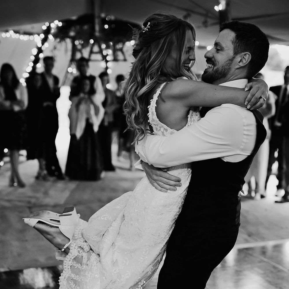 Groom lifts the bride and spins her around for the first dance 