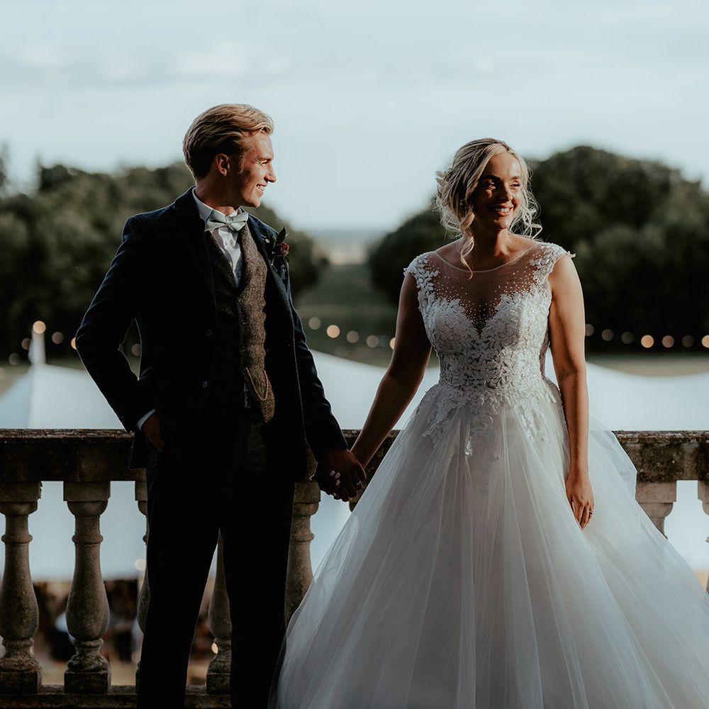 Bride in a tulle princess skirt wedding dress with embellishments with the groom in a tweed suit with a sage green bow tie