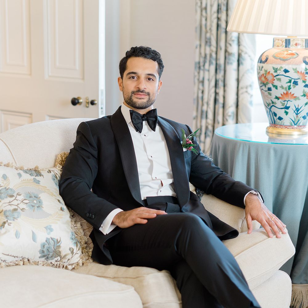 Groom wears black tie complete with floral buttonhole 