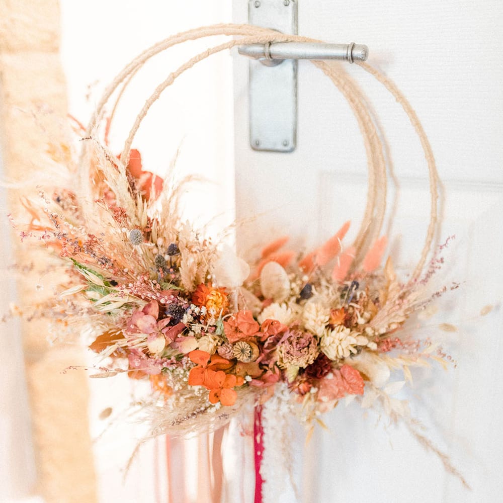 Autumnal coloured dried wedding flowers complete with rope and ribbon to the bottom