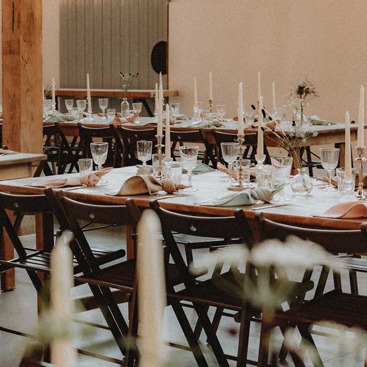 Industrial and DIY wedding setting complete with white candles and wildflower arrangements 
