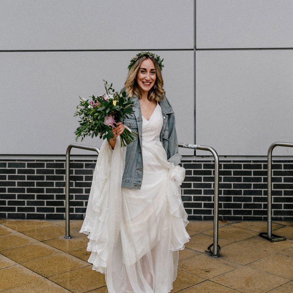 Boho bride wearing a flower crown and light blue bridal denim jacket for London wedding 