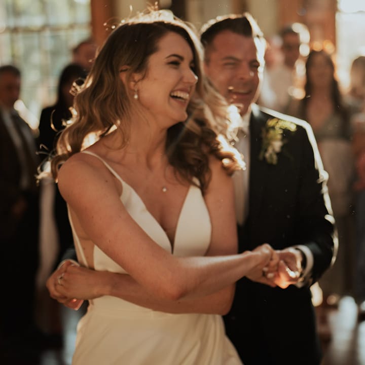 The bride and groom can't stop smiling as they have their first dance together 