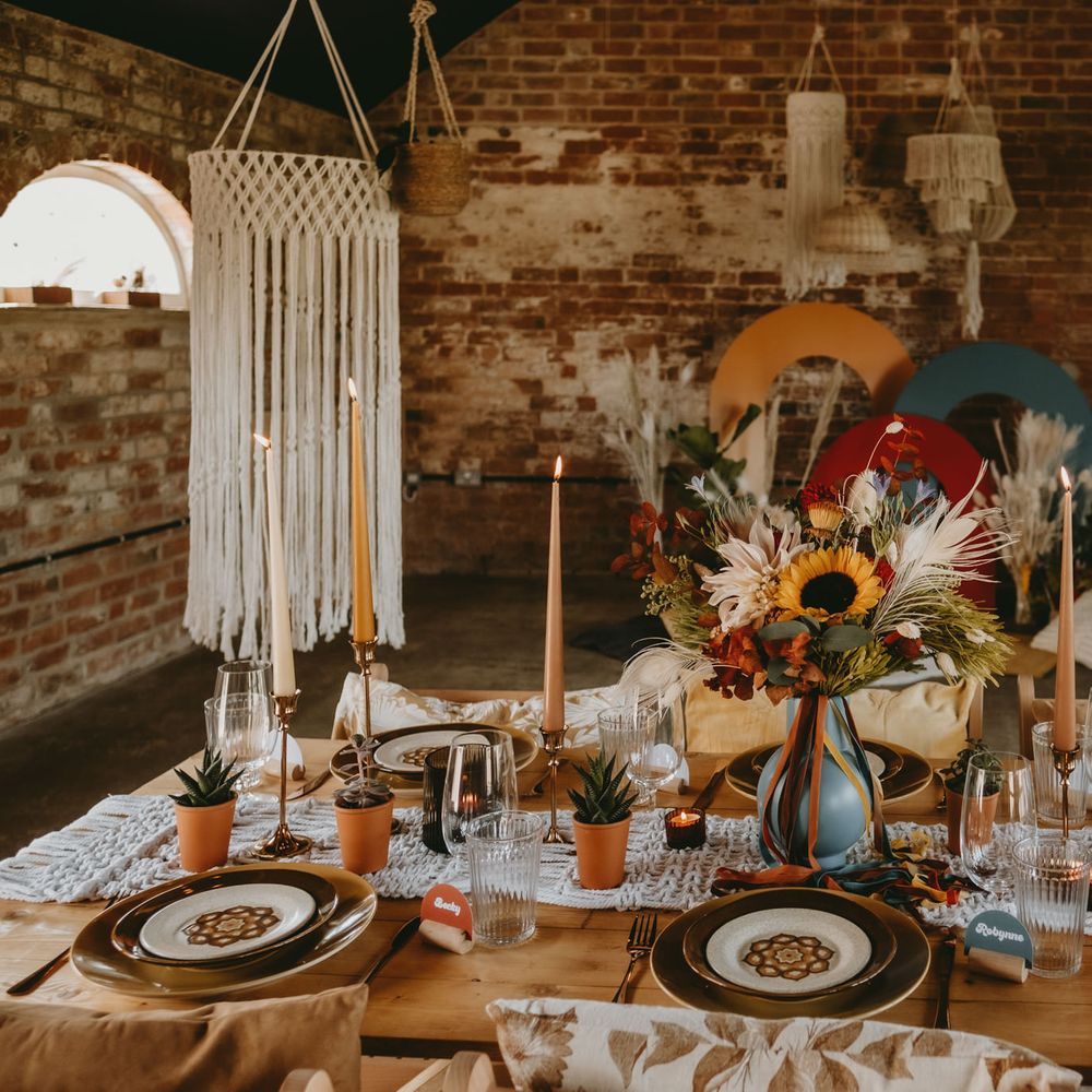 70s tablescape decoaration with sunflowers, patterned tableware and candles 