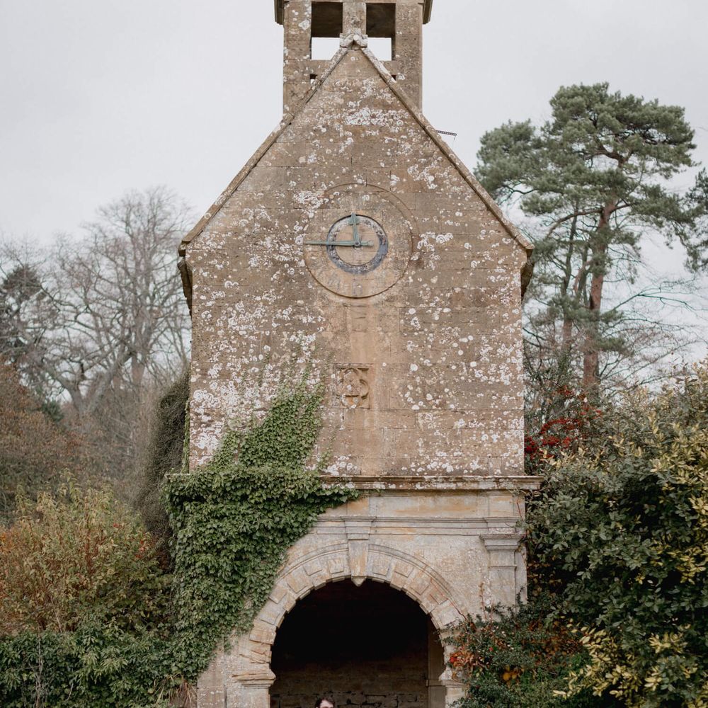 Newly wed bride and groom photography outside chapel on wedding day 