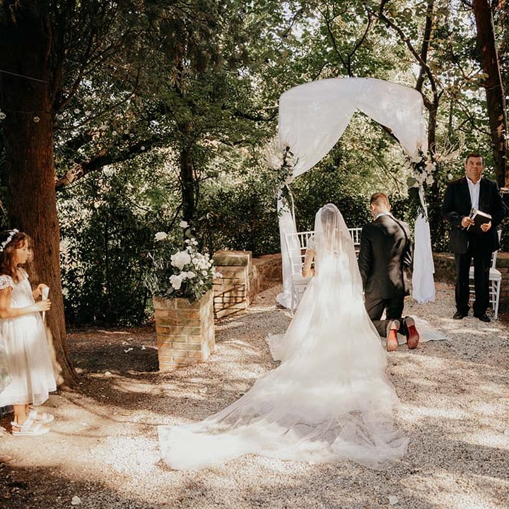 Bride & groom kneel outdoors during wedding ceremony | Royal Studio