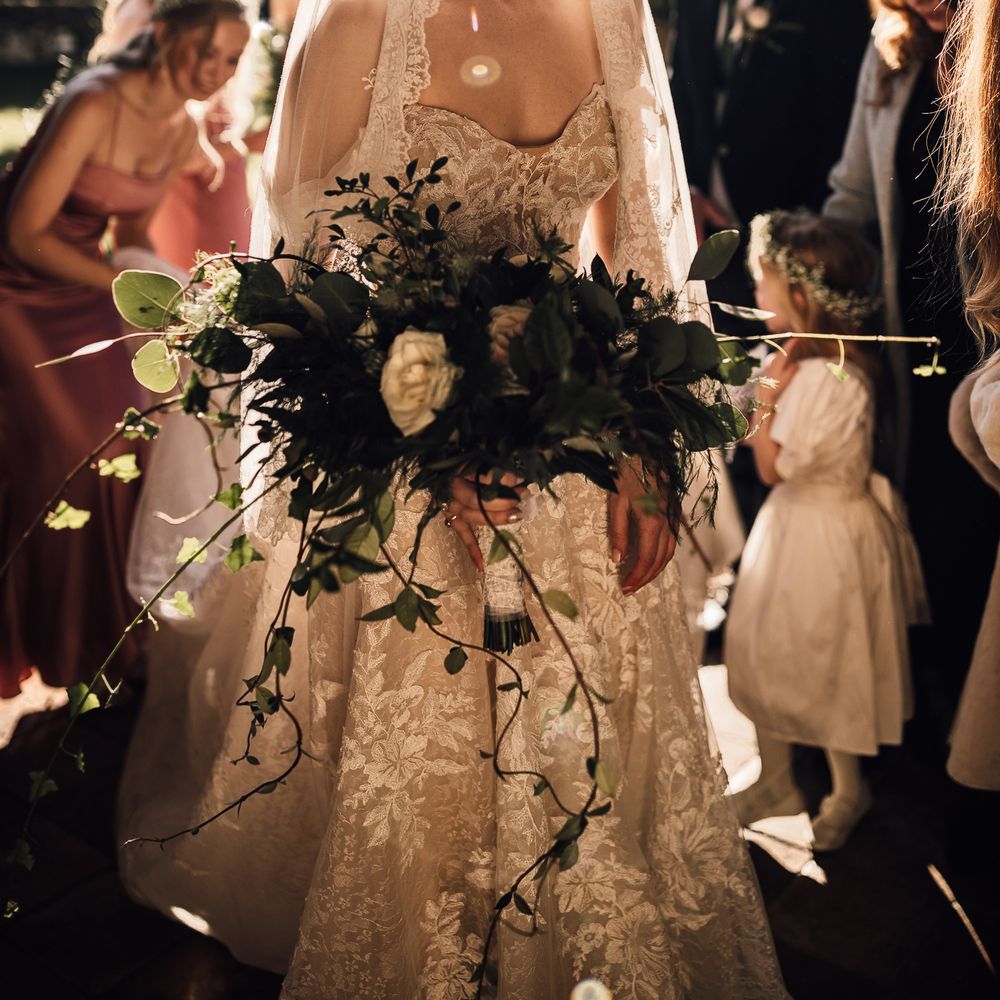 Bride stuns in lace trim veil with low bun hairstyle
