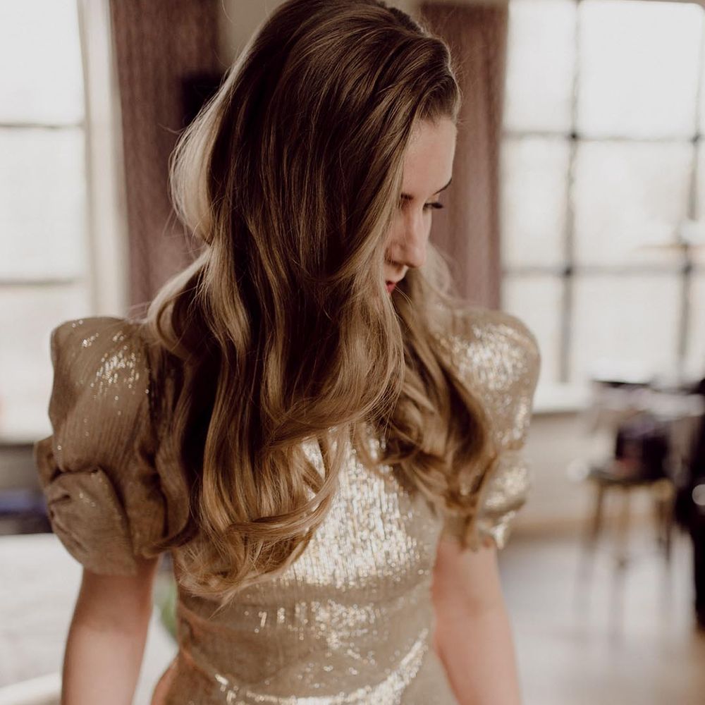 Bride wearing sparkly gold wedding dress with puff sleeves and bow detail for industrial wedding 