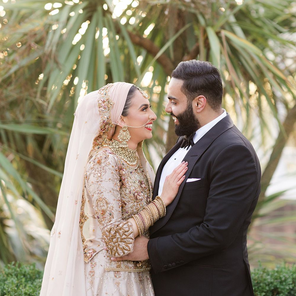 Bride wears traditional saree on her wedding day as she places a hand on her groom who wears black tie 