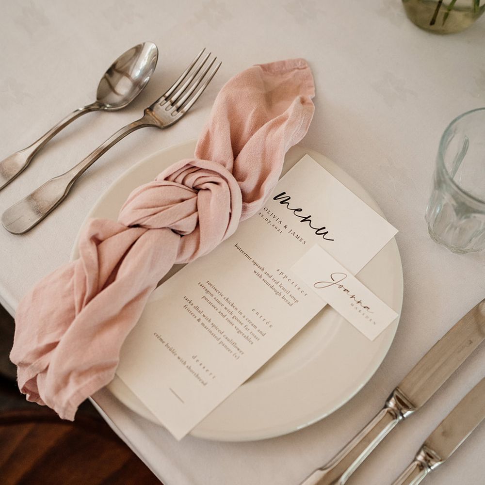 Simple table setting with black and white menu card and place name cards with pink napkin