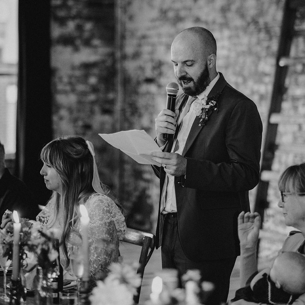 Groom gives speech during relaxed reception at Scale Liverpool in black & white image
