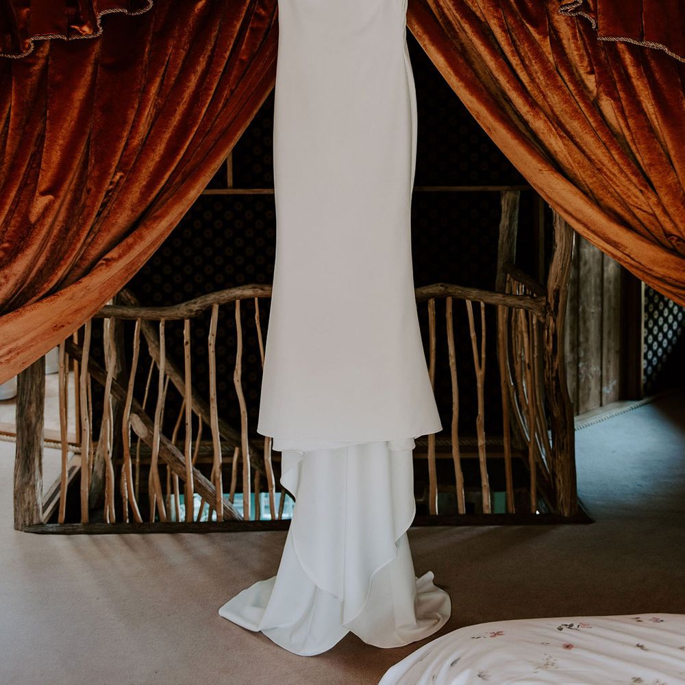White satin Made With Love wedding dress hanging up 