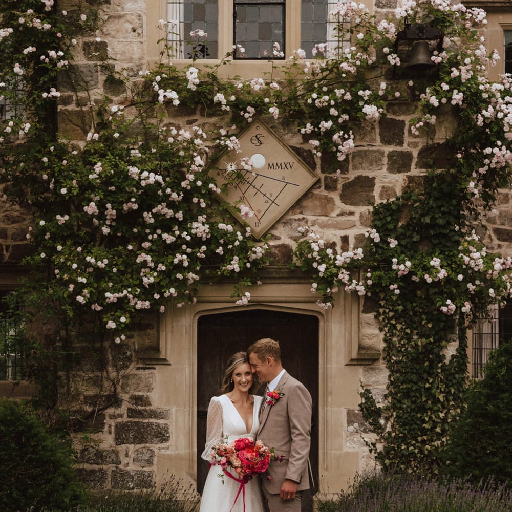 The Courtyard wedding venue in Shropshire with the bride in a plunging neckline wedding dress from Sassi Holford with the groom in a beige three piece suit