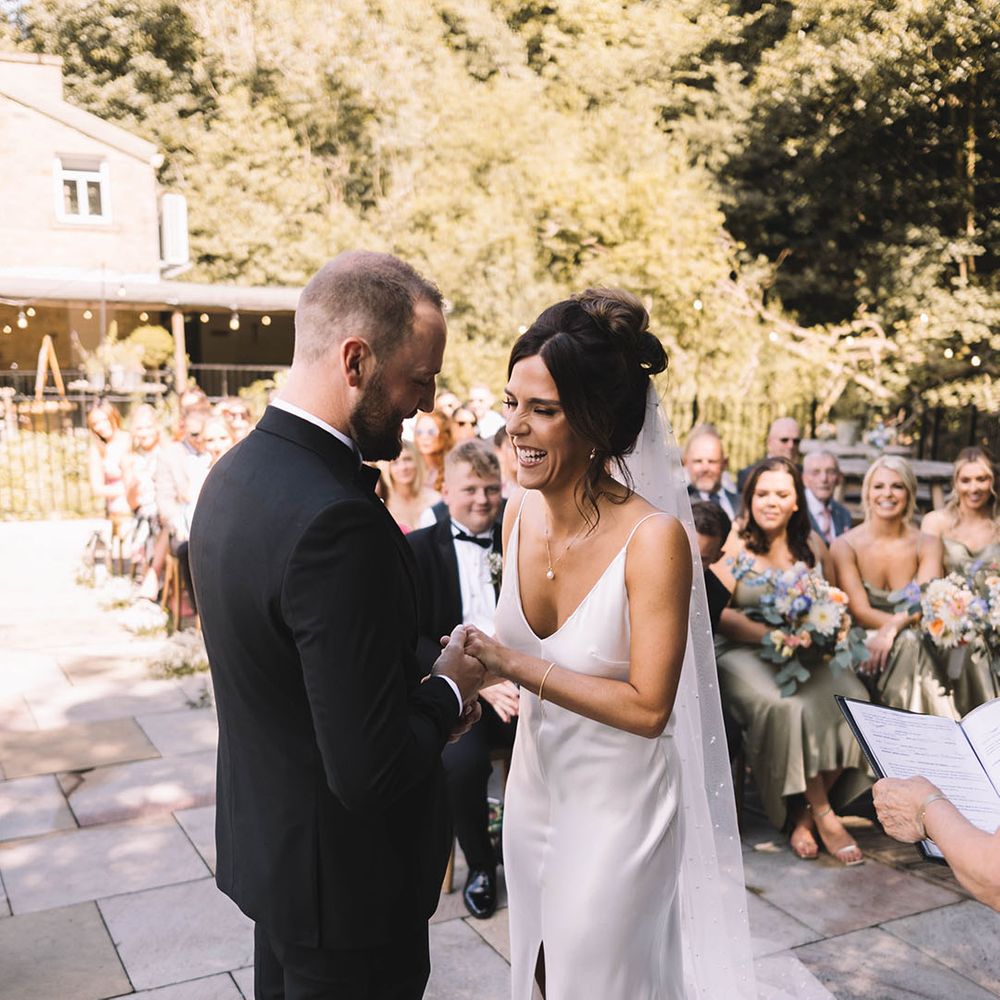 Bride in satin slip wedding dress with the groom in a black tuxedo 