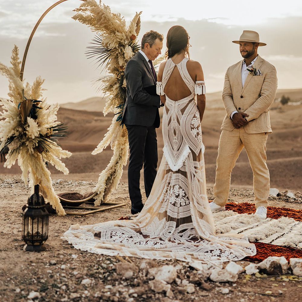 Bride in boho lace halter neck wedding dress with the groom at a destination wedding 