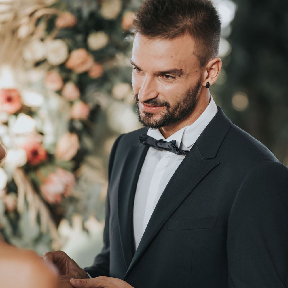 Groom in Armani suit holding his brides hand 