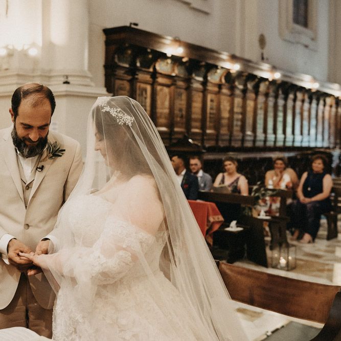 Groom slides ring on to Bride's hand in Tuscany