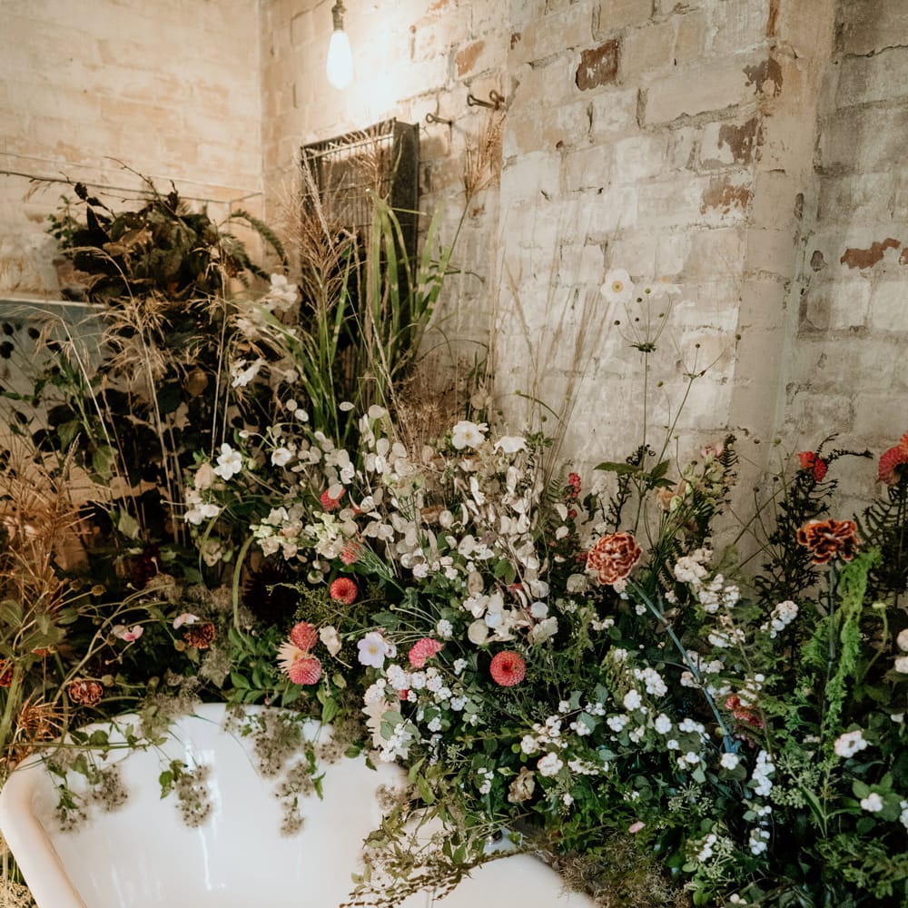 Roll top bath at Our Beautiful Glasshouse in Sussex decorated with wildflowers 