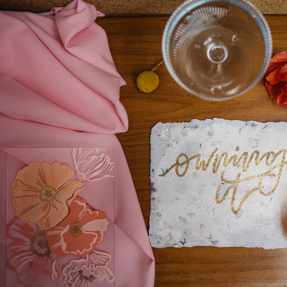 Hand drawn wedding stationery reading 'owning it' in gold calligraphy by Bee Davies