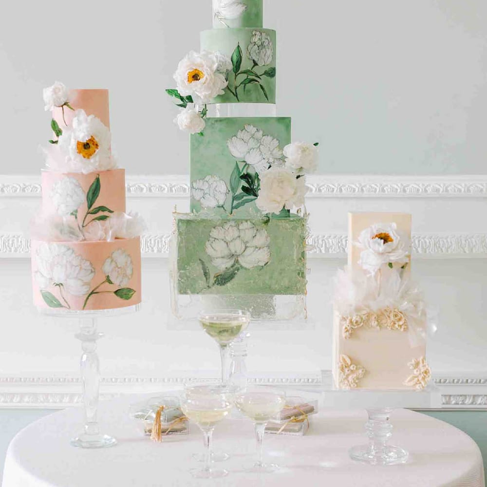 Four tier pale green wedding cake with square and round layers and flower illustration 