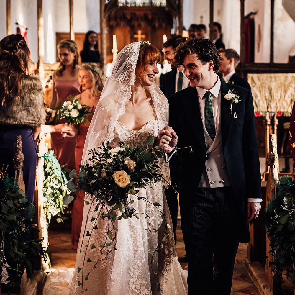 Bride carries large bouquet at church wedding ceremony