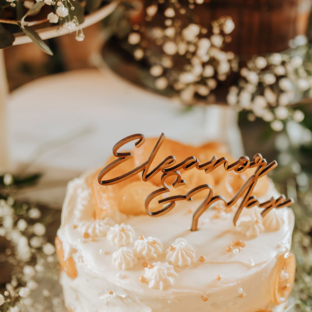 Personalised wooden wedding topper on white single tier wedding cakes with orange slice decor 