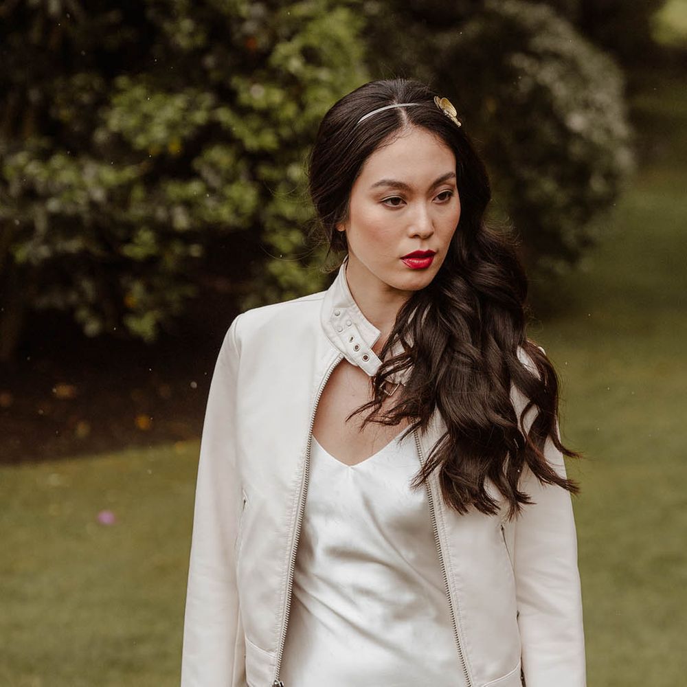 East Asian bride in a satin slip wedding dress, white jacket and metal headband 