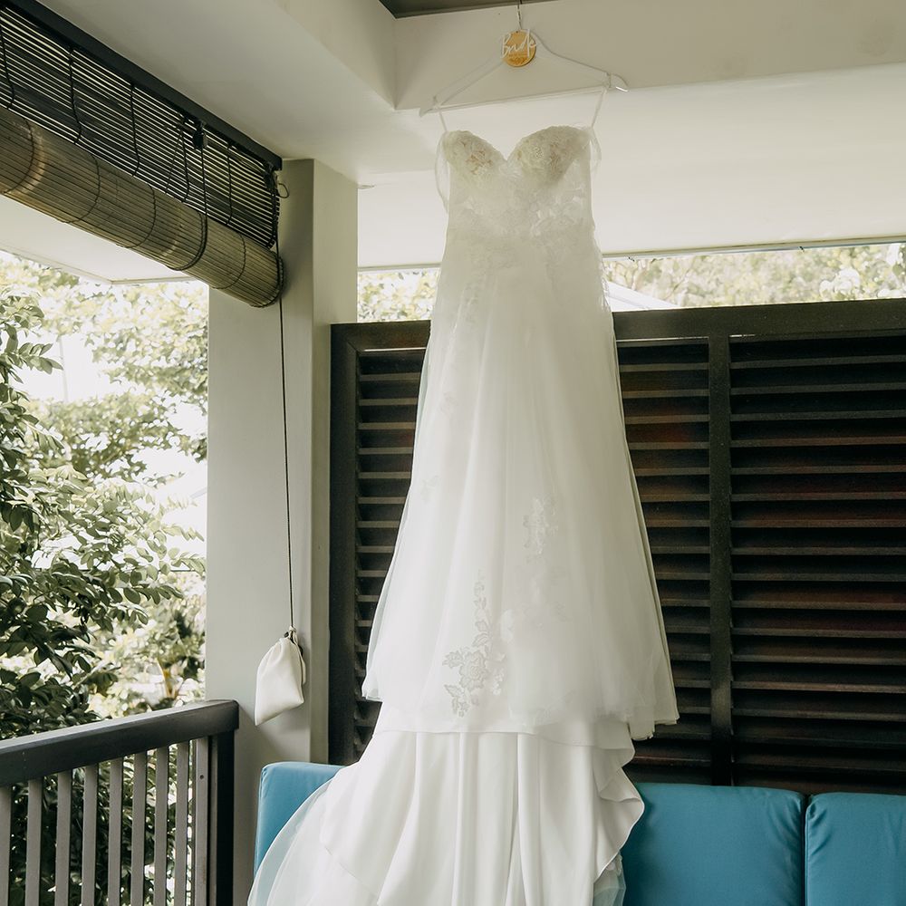 off the shoulder lace wedding dress with sweetheart neckline and lace floral details hanging up at Raffles hotel and resort in Seychelles