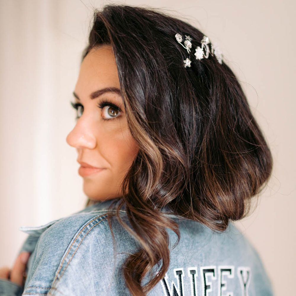 Bride in light blue denim jacket with sparkly details and pearls with letters spelling out 'WIFEY'