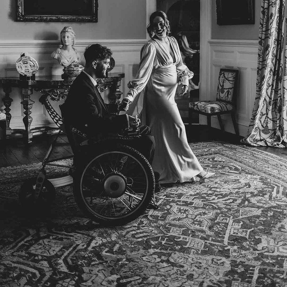 groom in a wheelchair and pregnant bride at Capesthorne Hall