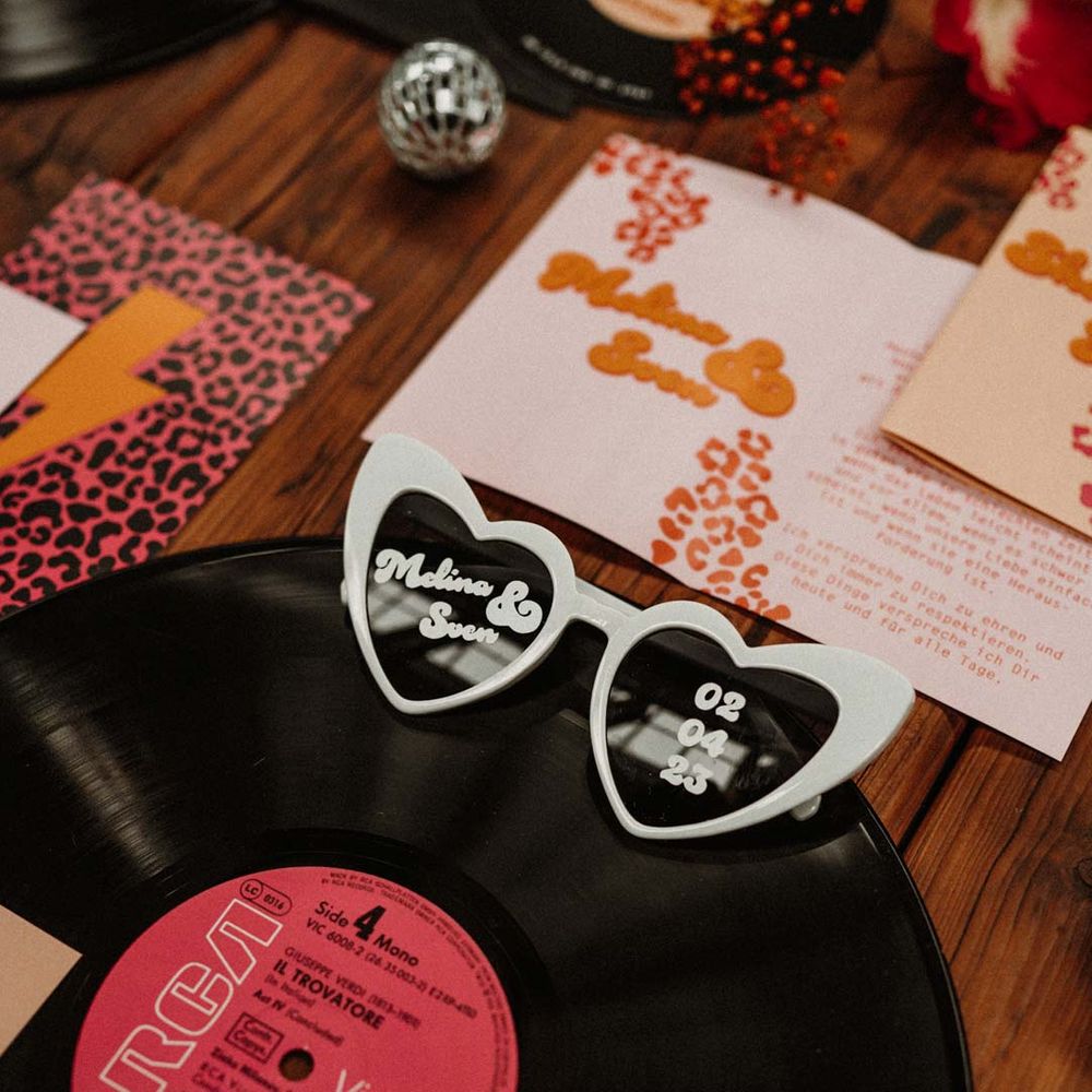 Vinyl record wedding decorations with heart shaped wedding sunglasses, leopard print wedding stationery and disco ball wedding decor