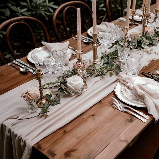 Intimate woodland wedding table with charger plates and candlesticks