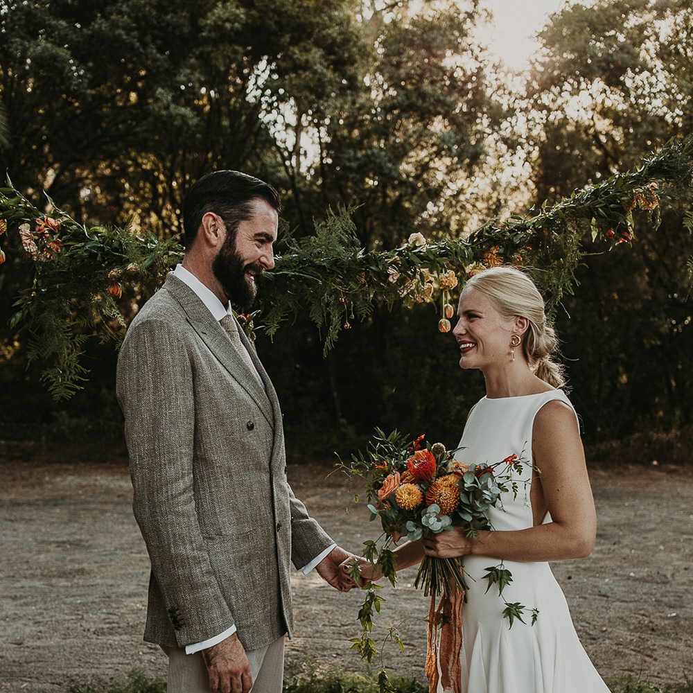 Bride and groom holding hands at outdoor wedding ceremony 
