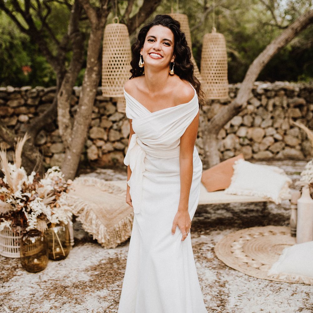 Bride laughs outdoors with wicker lampshades in Mallorca countryside