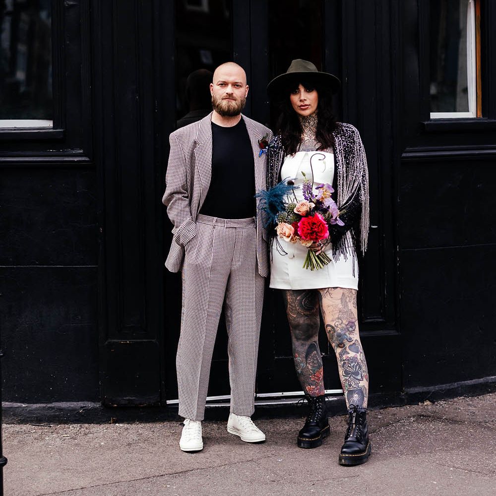 Alternative wedding inspiration in Shoreditch with groom in a check suit and trainers and bride in a short wedding dress and boots