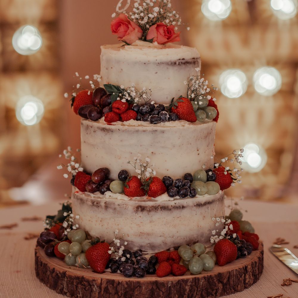 Wedding cake with naked frosting and fruit decoration 