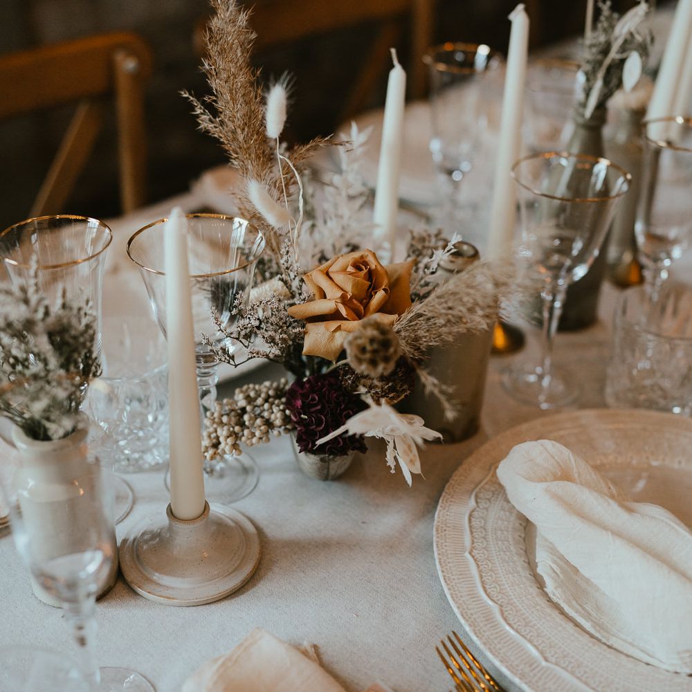 Dried and fresh flower stems in bottles at modern luxury wedding reception 