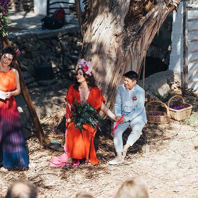 Brides sit down during wedding ceremony outdoors in Menorca