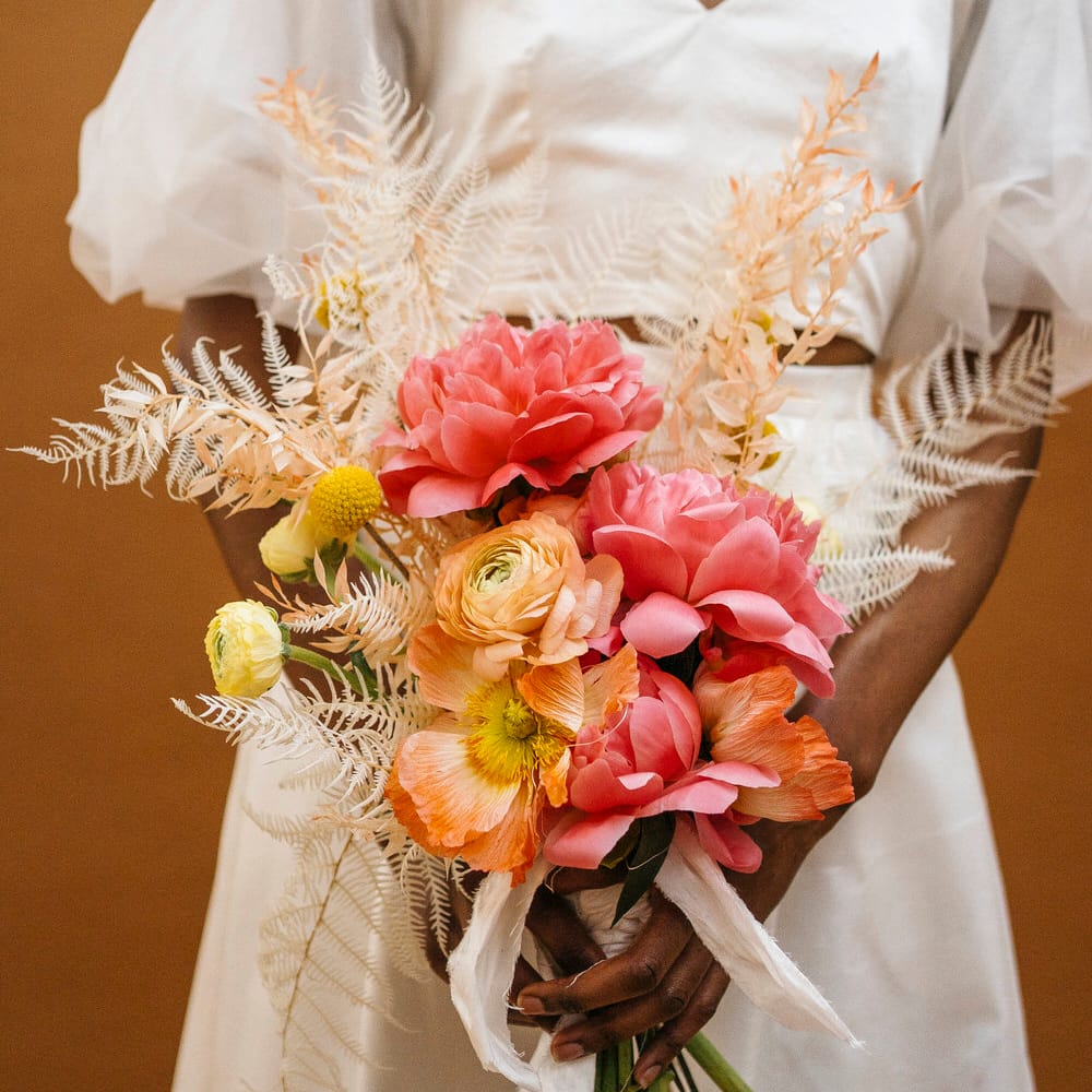 Pink, orange and yellow floral bouquet of poppies, dahlias and craspedia