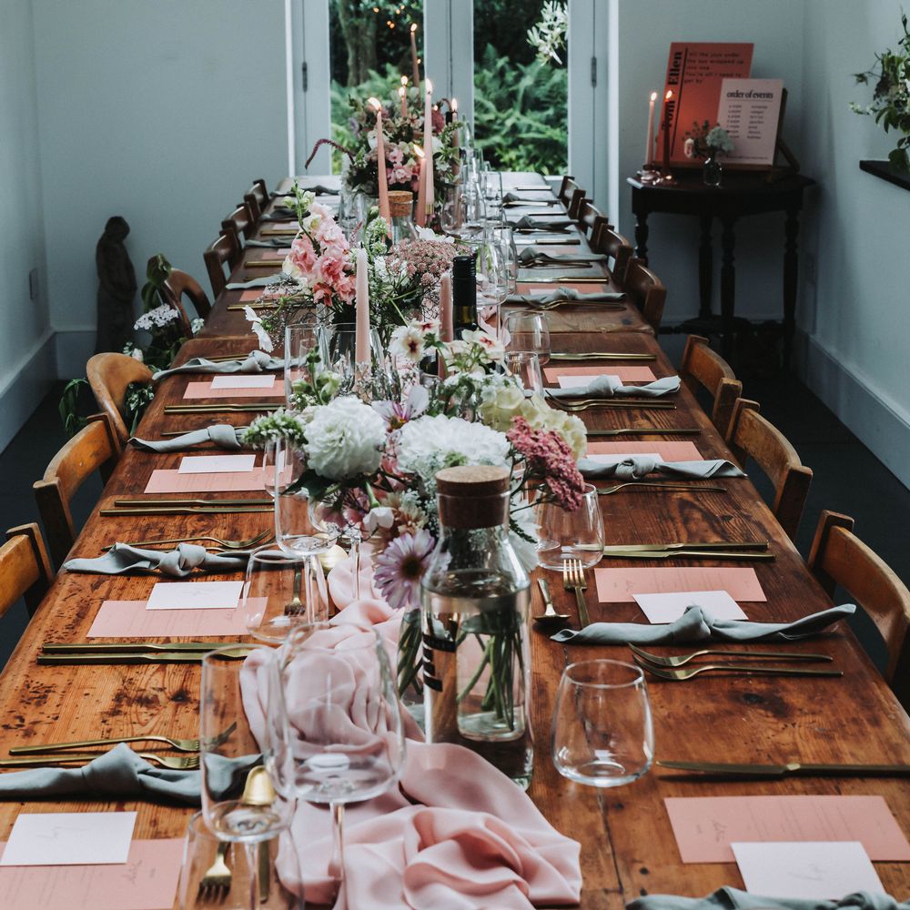 Pink table runner across wooden table complete with pink and white florals