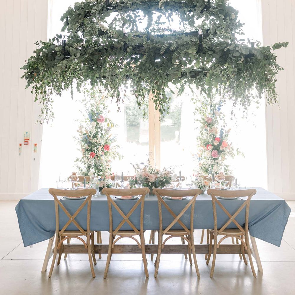 Hanging chandelier at The White barn decorated with foliage 