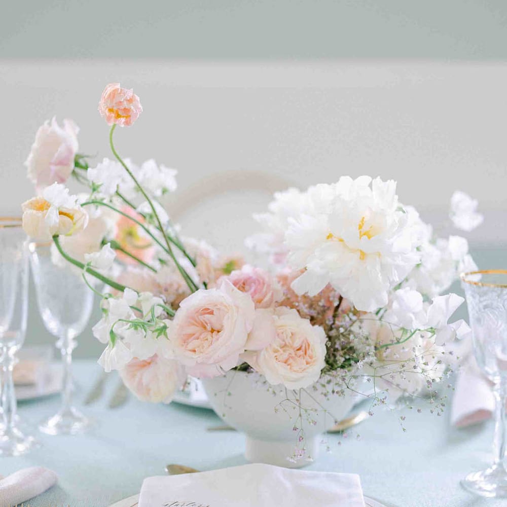 Place setting with roses, peonies, Icelandic poppies, sweet peas, scabious, foxglove, and snapdragon floral centrepiece 
