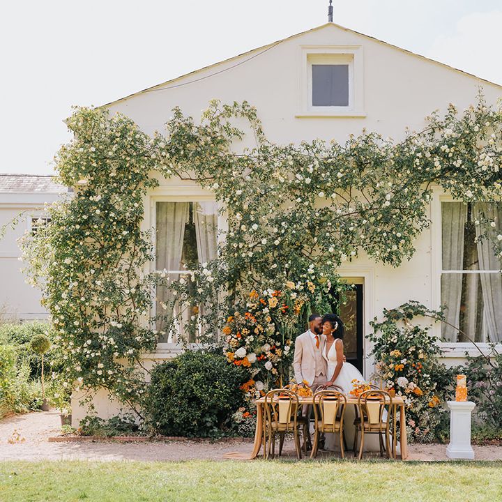 Outdoor wedding reception at Manor Hall, London with orange flowers and decor 