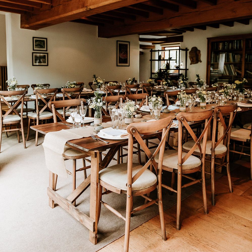 Rustic and cosy setting for reception area at Chaucer Barn with small white flower arrangements