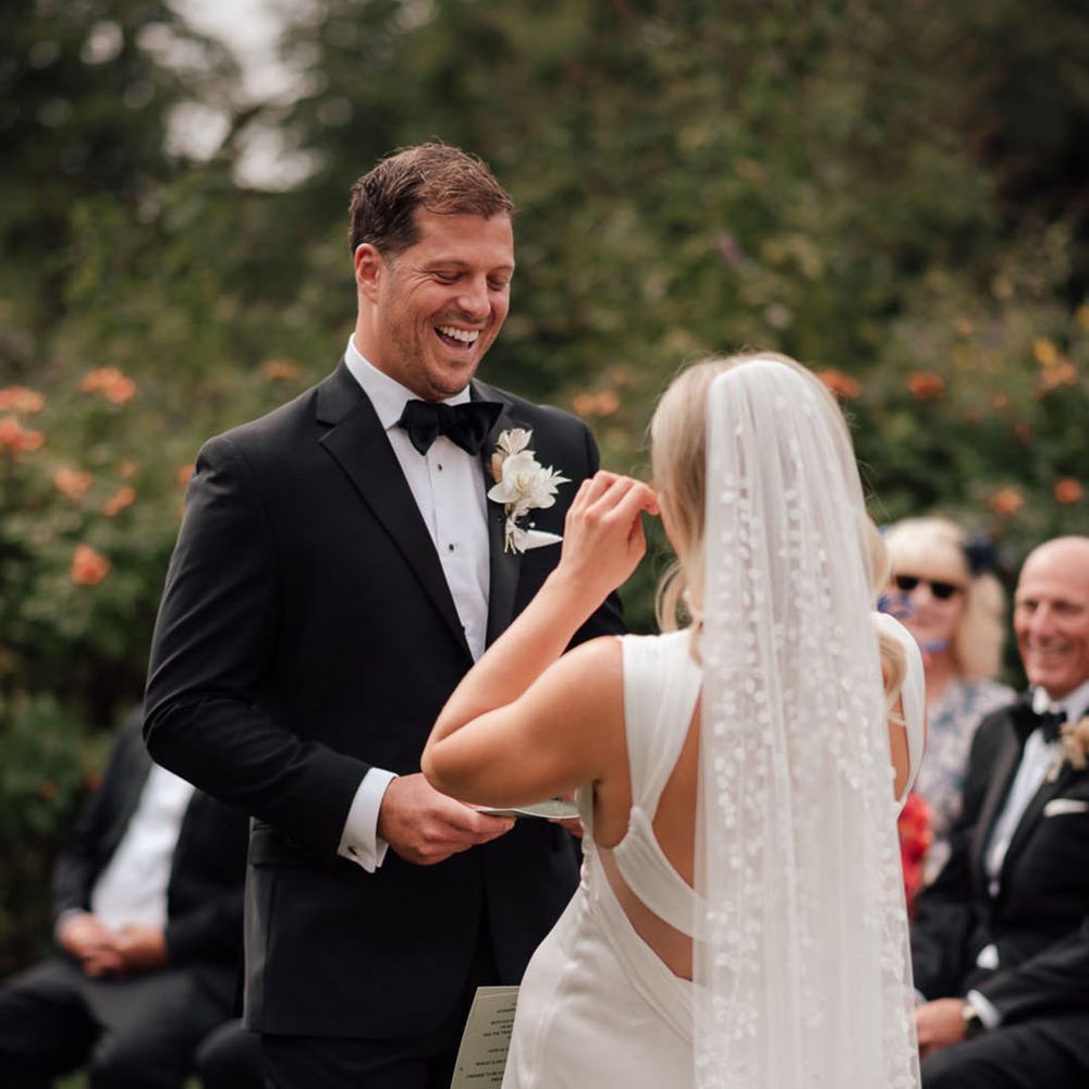  The groom in a black tuxedo reads out his wedding vows for the humanist wedding ceremony 