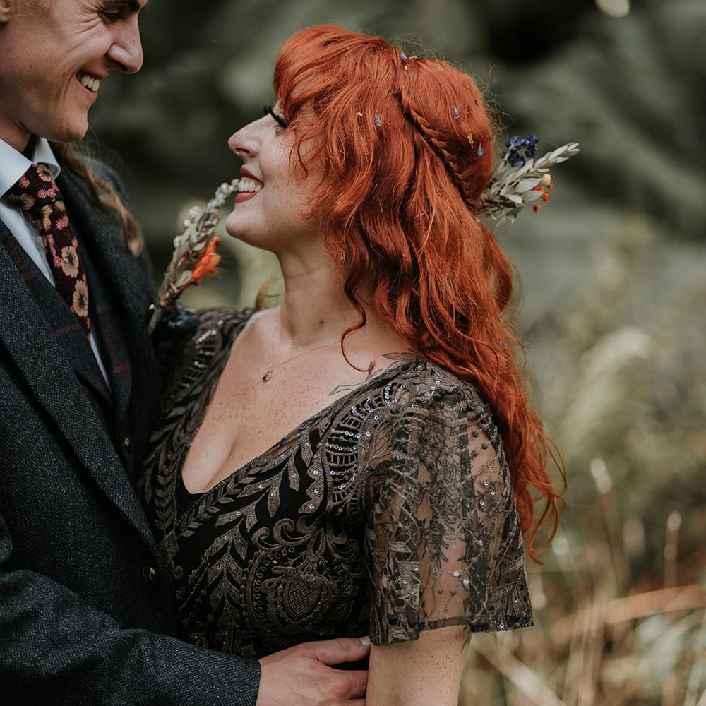 Bride in v neck embellished short sleeve black wedding dress and dried flower hair accessory 