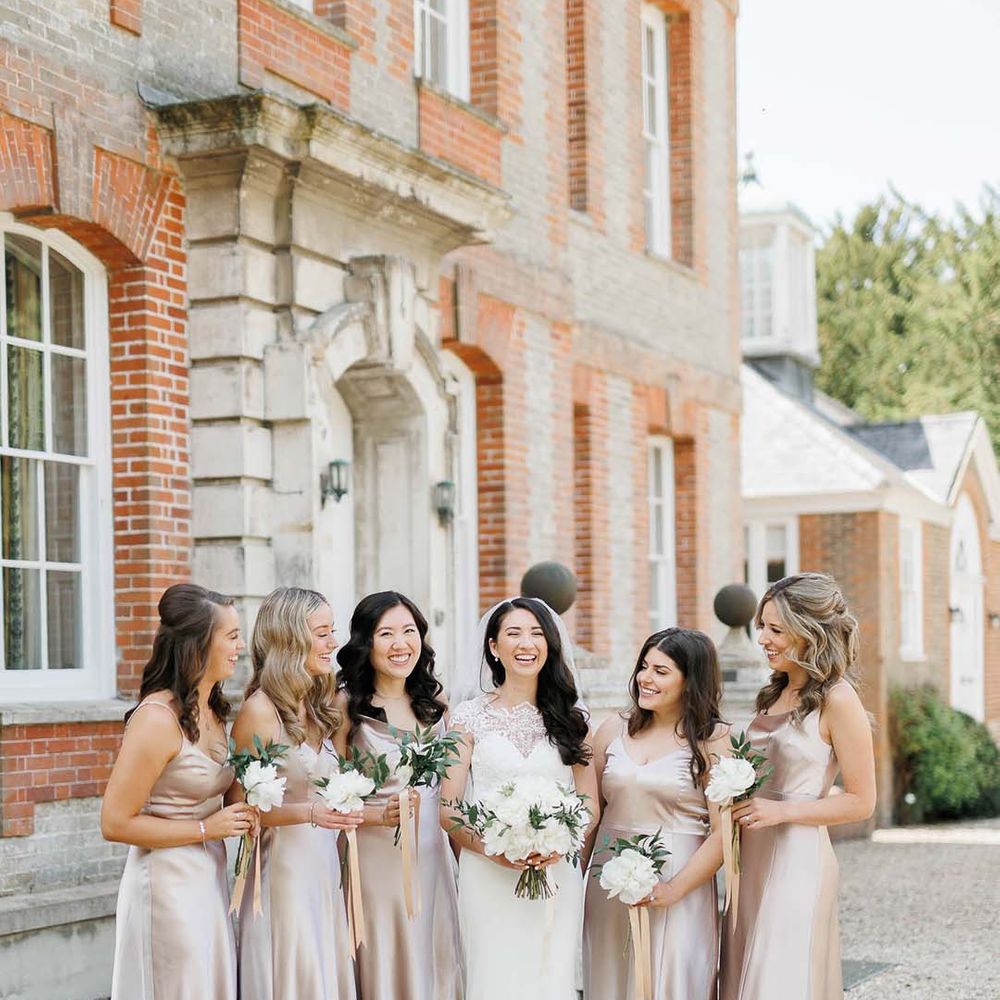 bridal party with bride in a Pronovias wedding dress and bridesmaids in pink satin bridesmaid dresses