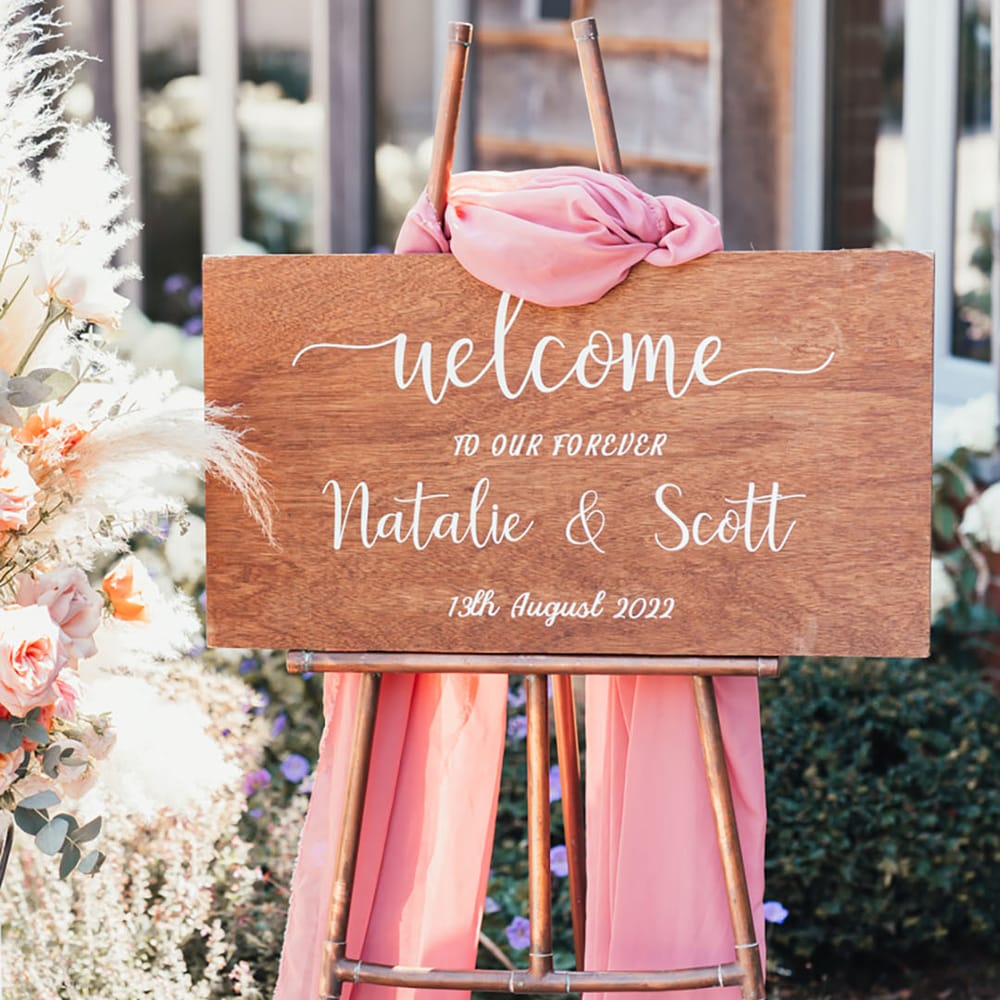 Wooden rustic wedding welcome sign with pink drapery with pampas grass decor 