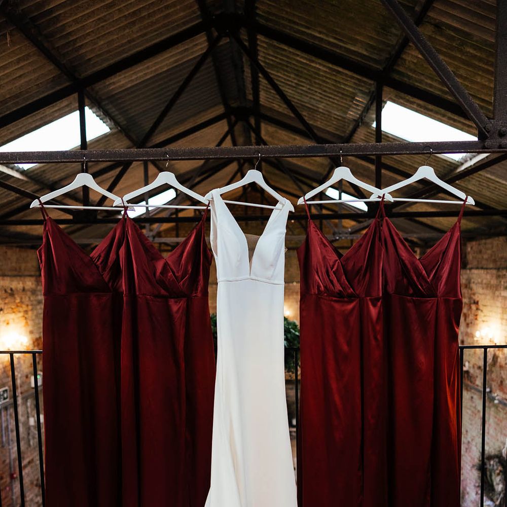 The bride's Savin London wedding dress hanging up with the bridesmaid dresses for the autumn wedding 